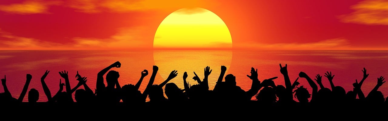 Menschen bei einer Party mit Sonnenuntergang im Hintergrund