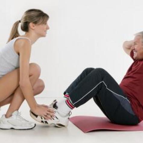 Starker Rücken Mann macht Sit ups mit Trainerin Starker Rücken Mann macht Sit ups mit Trainerin