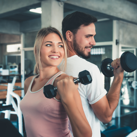 Krafttraining ist beim Abnehmen wichtig Eine Frau und ein Mann trainieren mit Hanteln