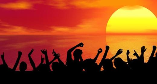 Menschen bei einer Party mit Sonnenuntergang im Hintergrund