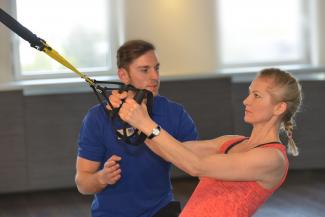 Coach mit Mitglied am TRX im Body Up